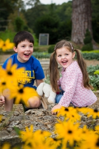 Laughing in the flowers, children's portraiture by Sarah Hart Photography, Ightham Mote, Kent