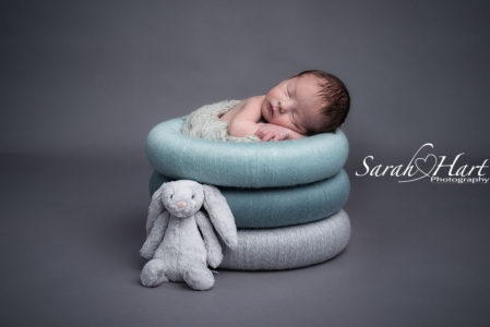 Newborn baby in posing rings, teals and greys, with little bunny, Kent baby photographer