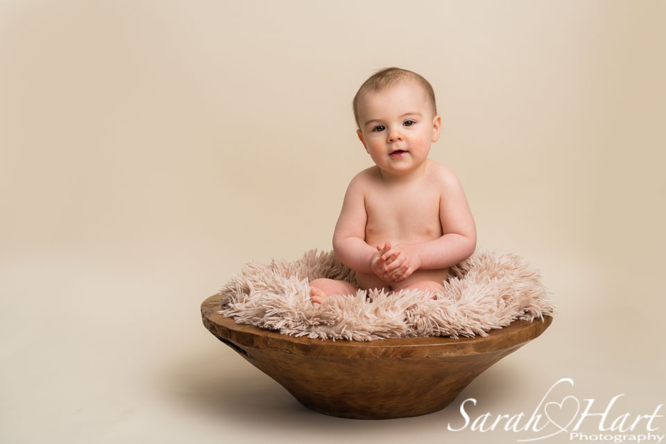 baby in a wooden bowl, inquisitive baby expressions, studio photography in tonbridge