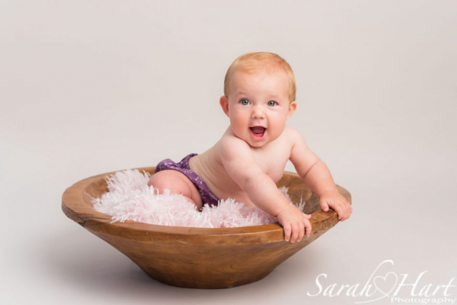 cute baby photos, baby sat in pink fur and large wooden bowl, baby photos by Sarah Hart
