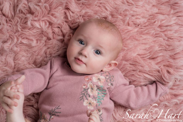 intense stare from baby, pink fur flokati, big blue eyes, Crowborough photographer