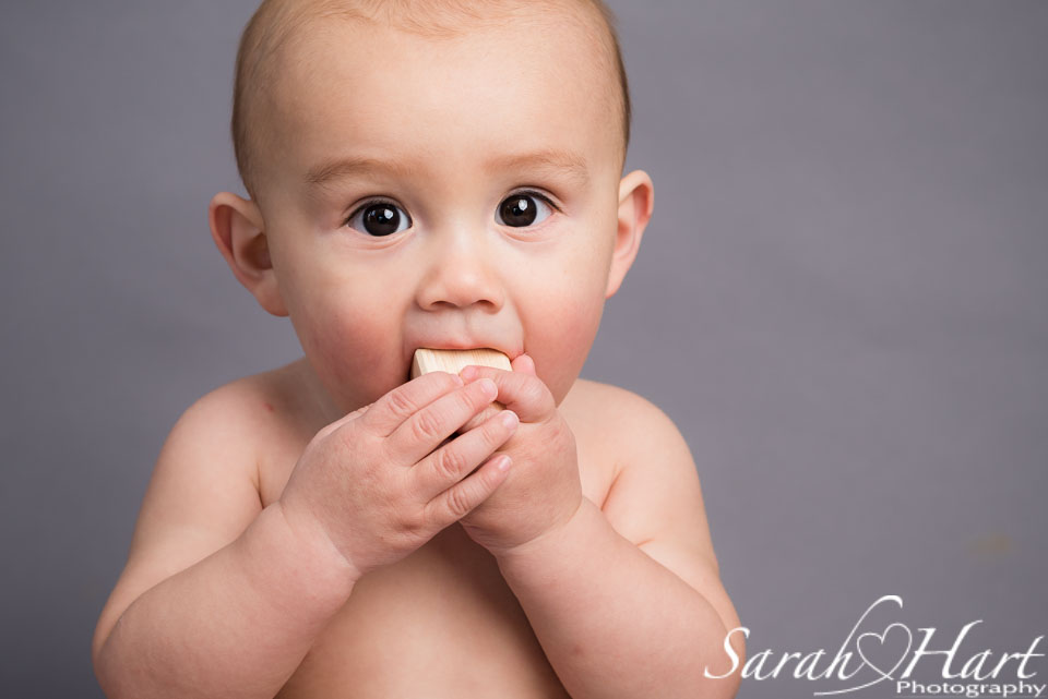 eating a wooden cube, gorgeous big brown eyes, 6 month old baby photo session, tunbridge wells baby photographer