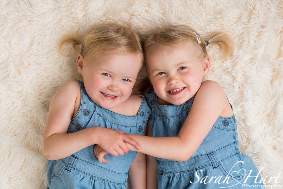 Twins cuddling on cream rug, sibling photographs, tonbridge photographer