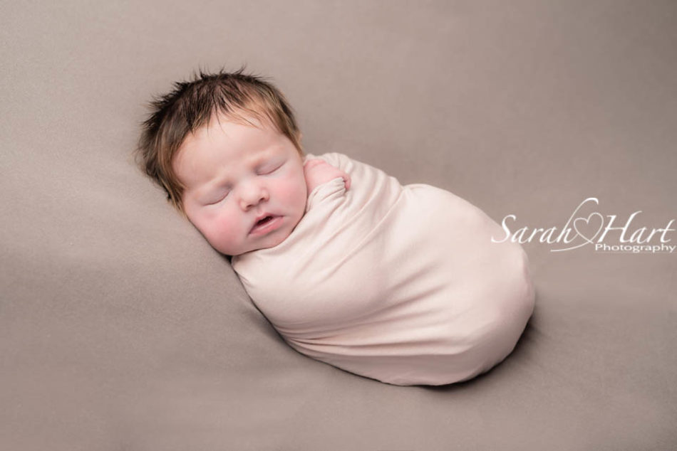 mushroom brown and blush pink, baby wrapped snuggly at her newborn session