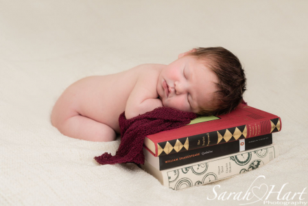 newborn photography session kent, baby resting on books