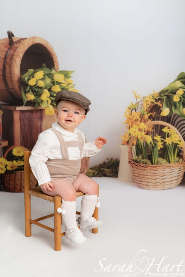 Little boy with a flat cap sat on a chair at Spring Photography Mini Session