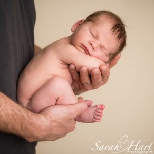 newborn baby boy held in father's hands, newborn photographer kent